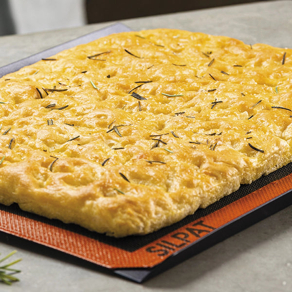 Square focaccia with herbs on a Silpat mat