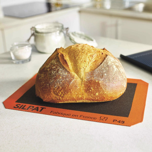 Loaf of bread on a Silpat baking mat in a kitchen setting
