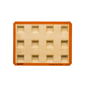 Freshly baked square brownies cooling on a wire rack
