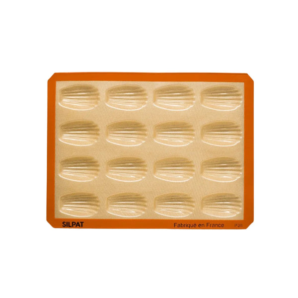 Freshly baked madeleines cooling on Silpat mold